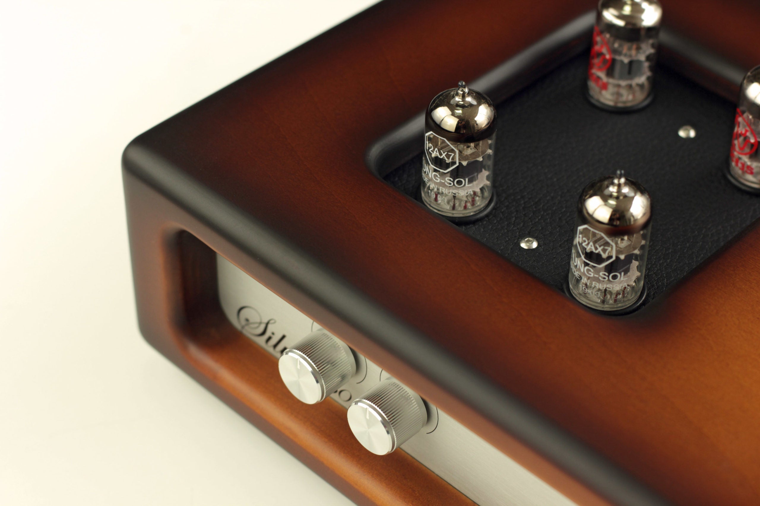 Wooden audio amplifier side view with silver knobs and front control panel details
