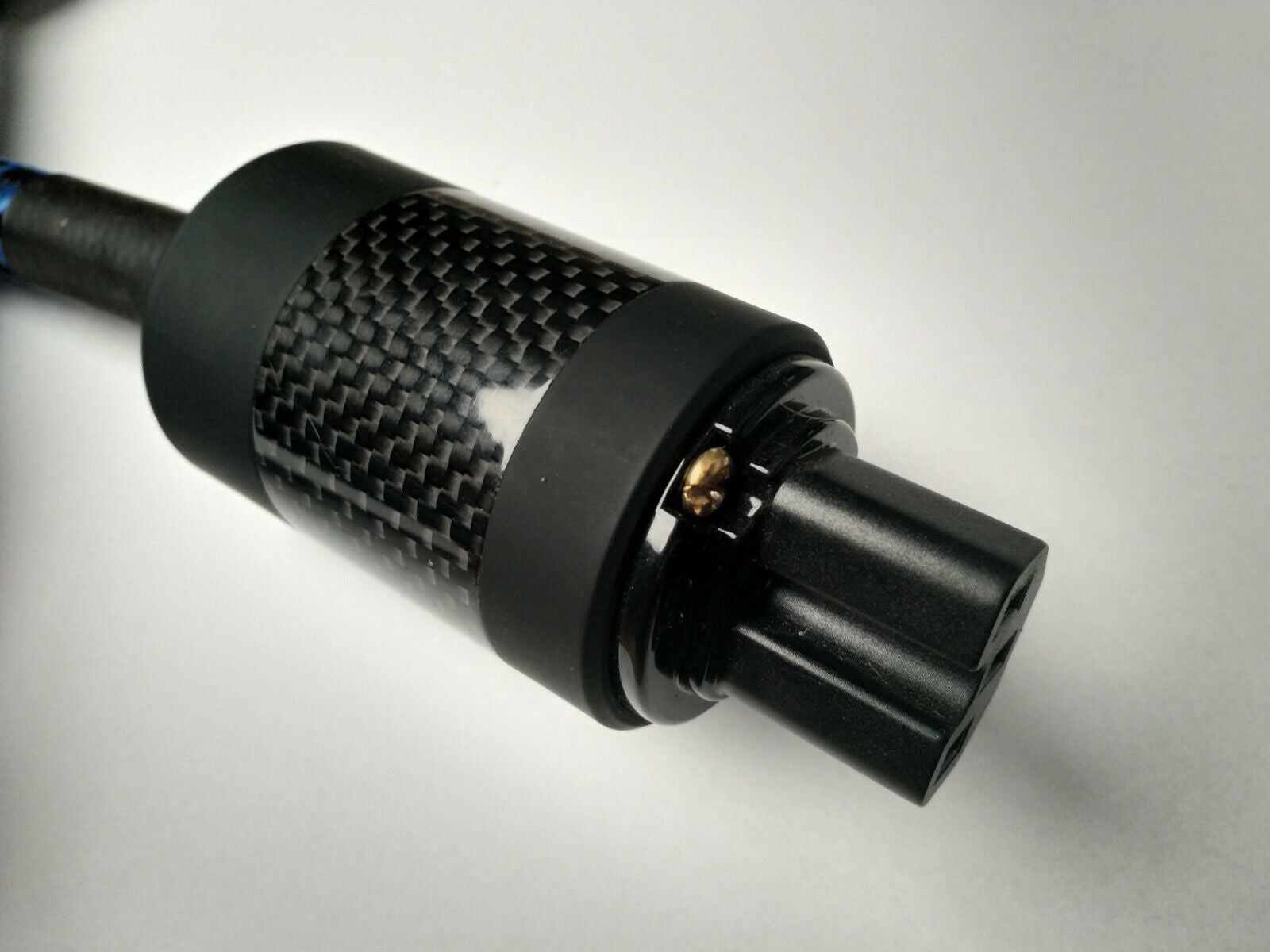 Black carbon-fiber IEC plug with gold contact pin and textured grip ring