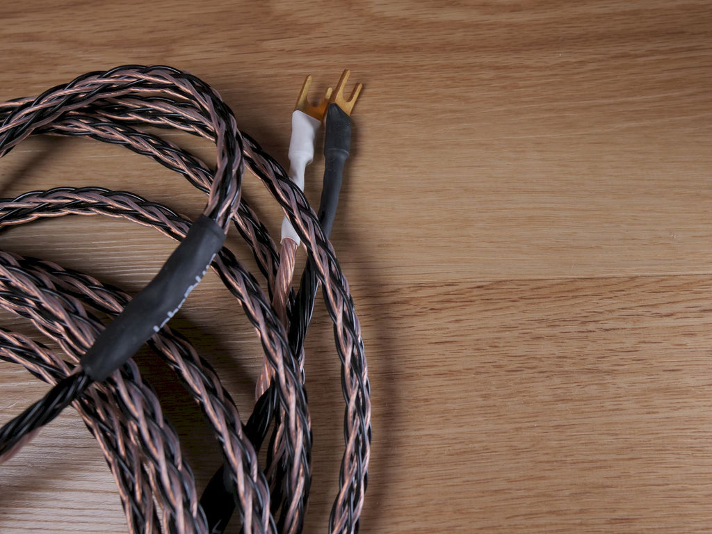 Speaker cable with black jacket and twisted conductors, gold prong ends