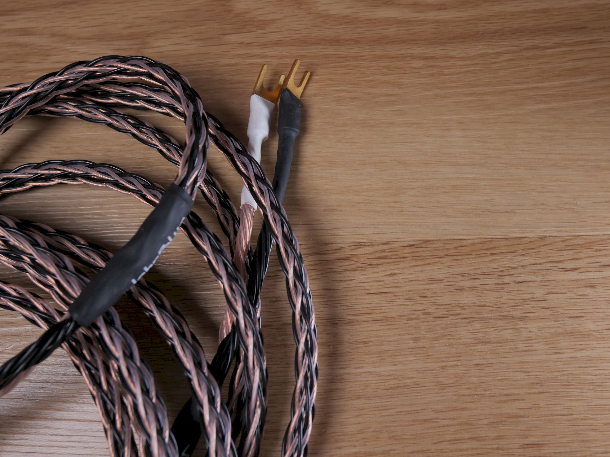 Speaker cable with black jacket and twisted conductors, gold prong ends