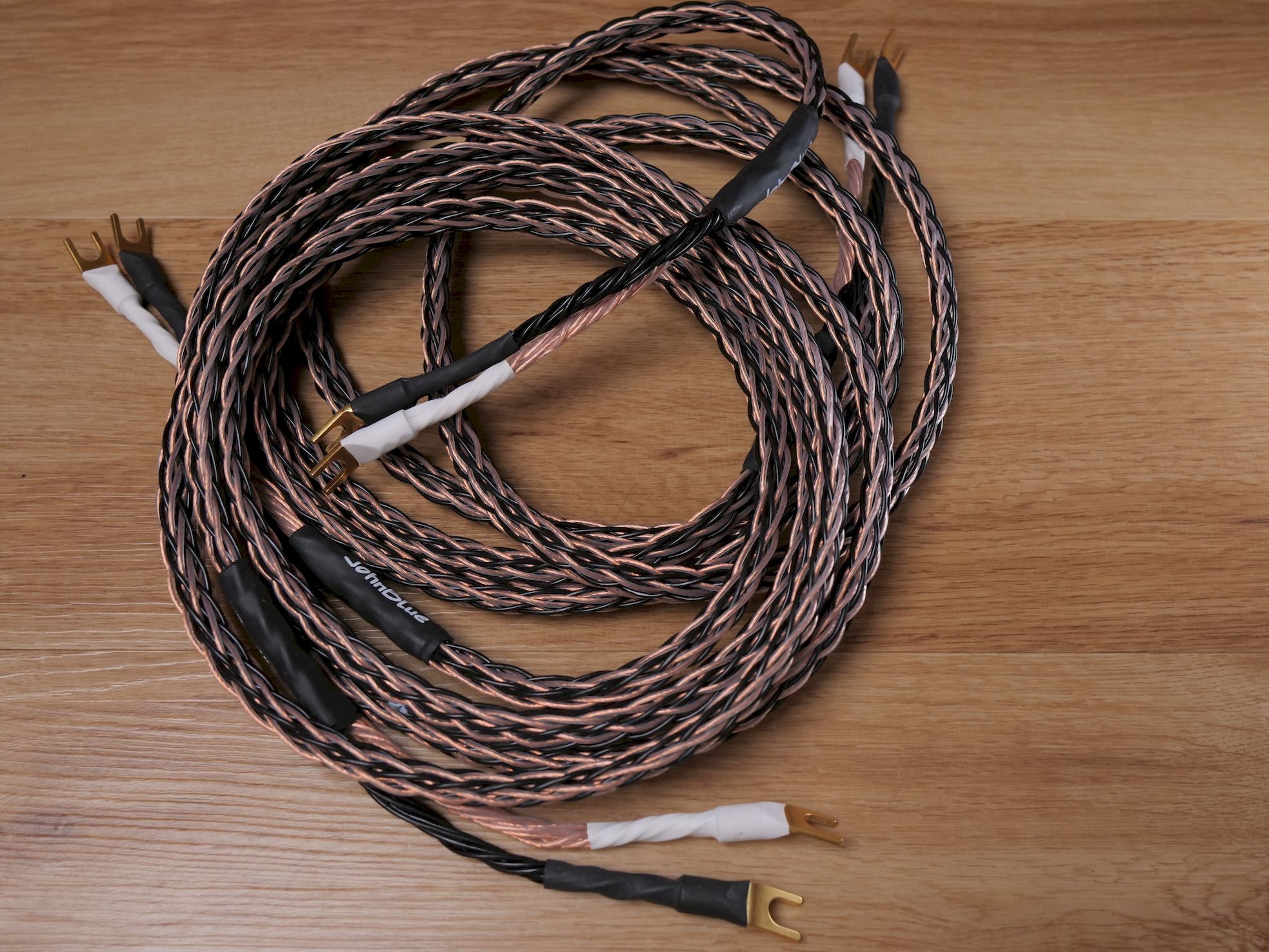Speaker cable set of twisted wires with black jacket and gold banana plug tips