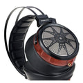 Over-ear headphones with black cushioned pads, round mesh grille, and wood-accent ring