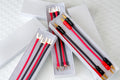 Jumper cable set with red and black wires and gold spade clamps in storage box