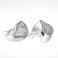 Silver-tone wireless earbuds with heart-shaped glitter face and white silicone tips