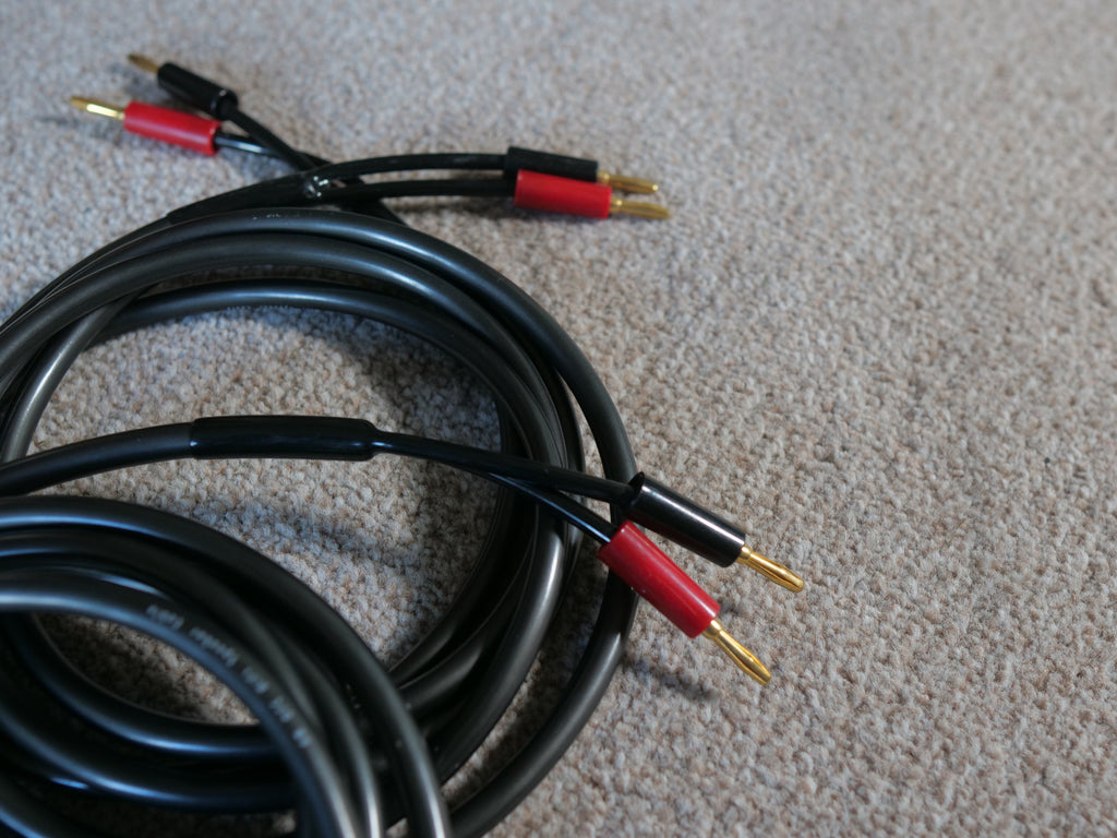 Black loudspeaker cable bundle with red banana plug ends and gold connectors