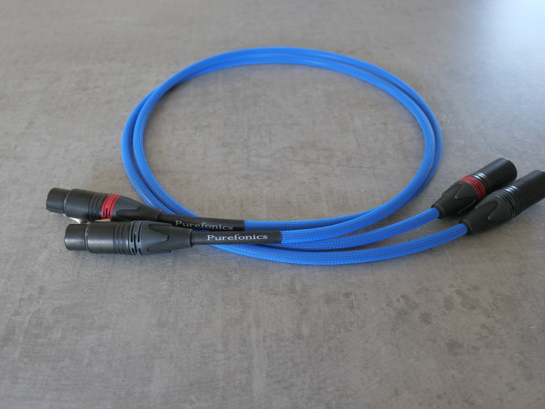 Blue XLR audio cable with black male connectors, bundled length for audio setup