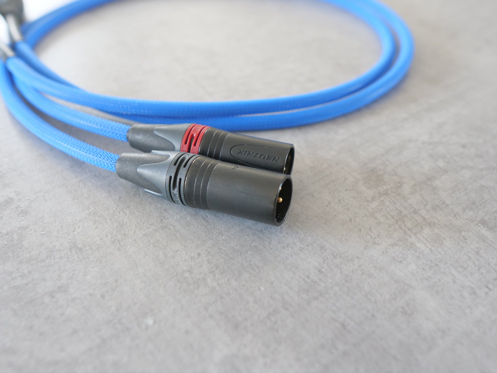 Blue XLR audio cable with two gray-black connectors and red band near plug