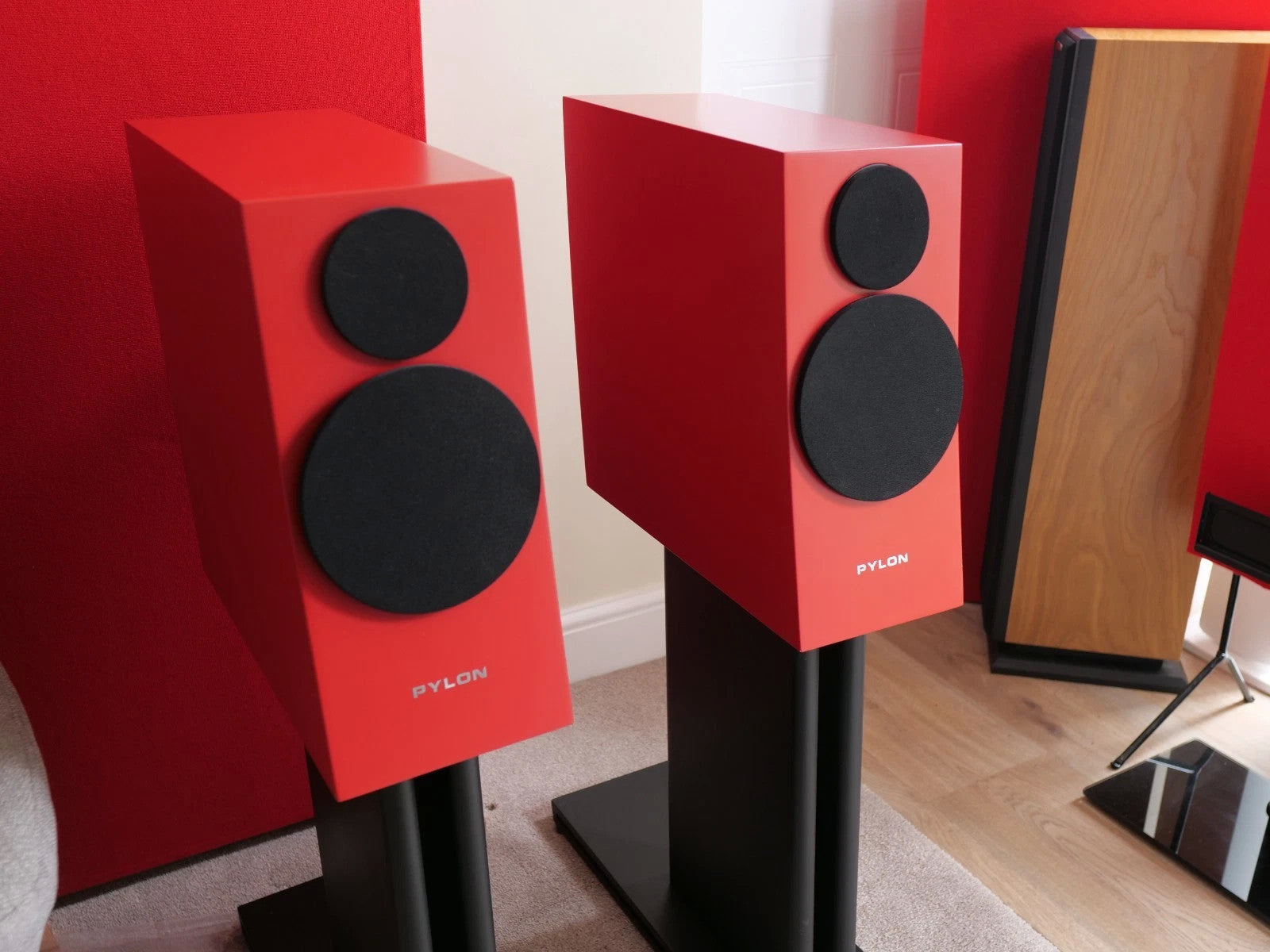 Pair of red speakers with two black drivers each on black floor stands