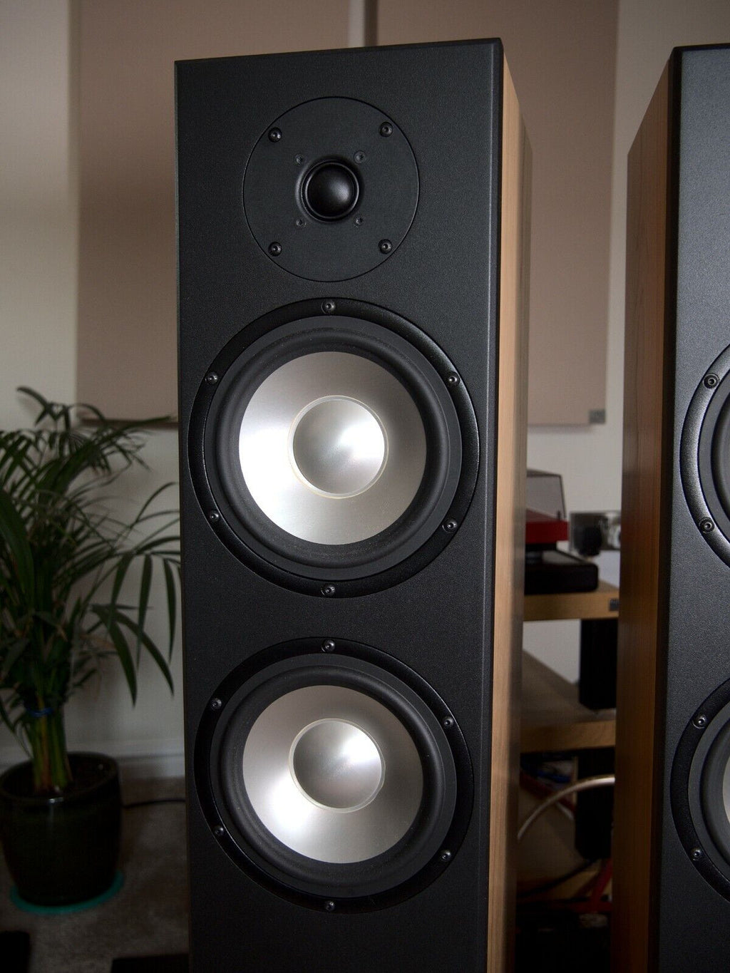 Black floor-standing speaker front with two illuminated woofers and tweeter