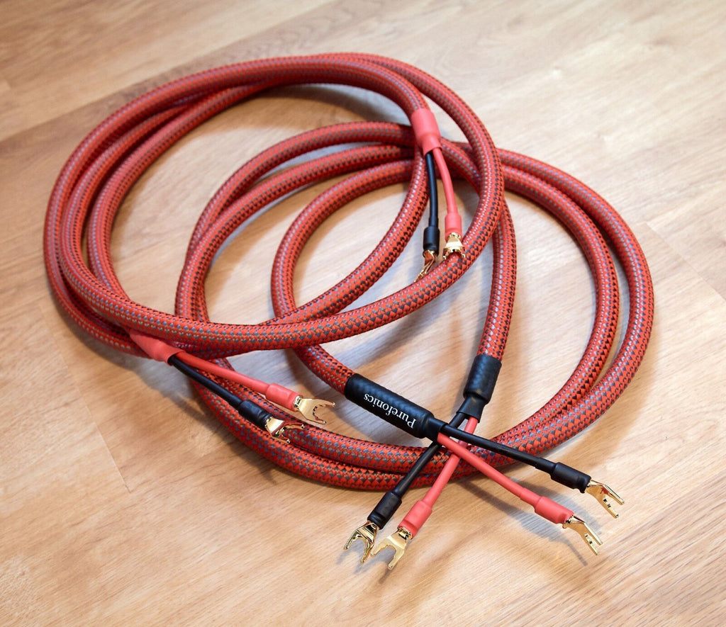 Red braided audio cables with gold-plated banana plugs and black connector ends
