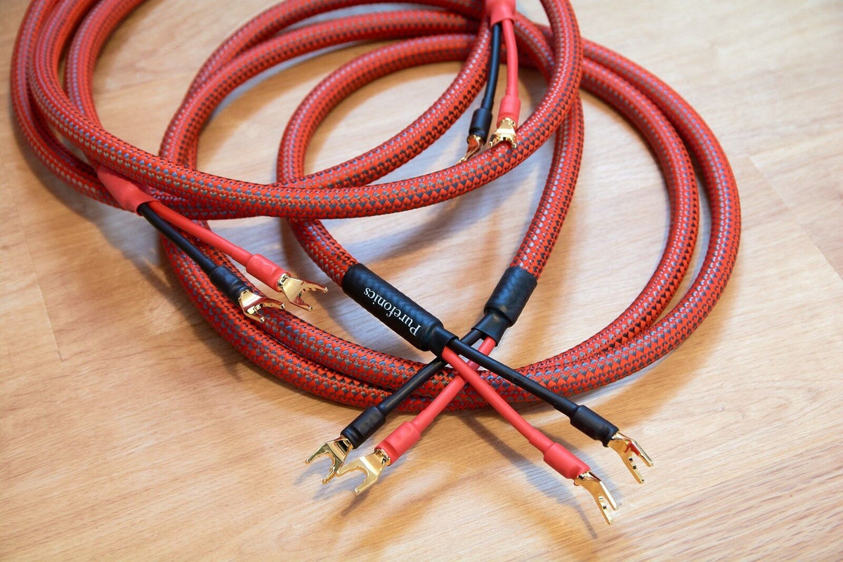 Red braided audio cables with gold-plated banana plugs and black connector ends in pairs