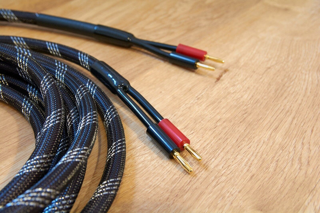 Braided black and blue audio cable with gold banana plugs and red accents