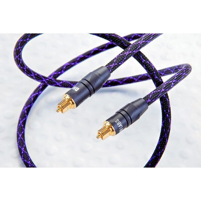 Purple braided audio cable, close-up of two gold RCA plugs on black connectors