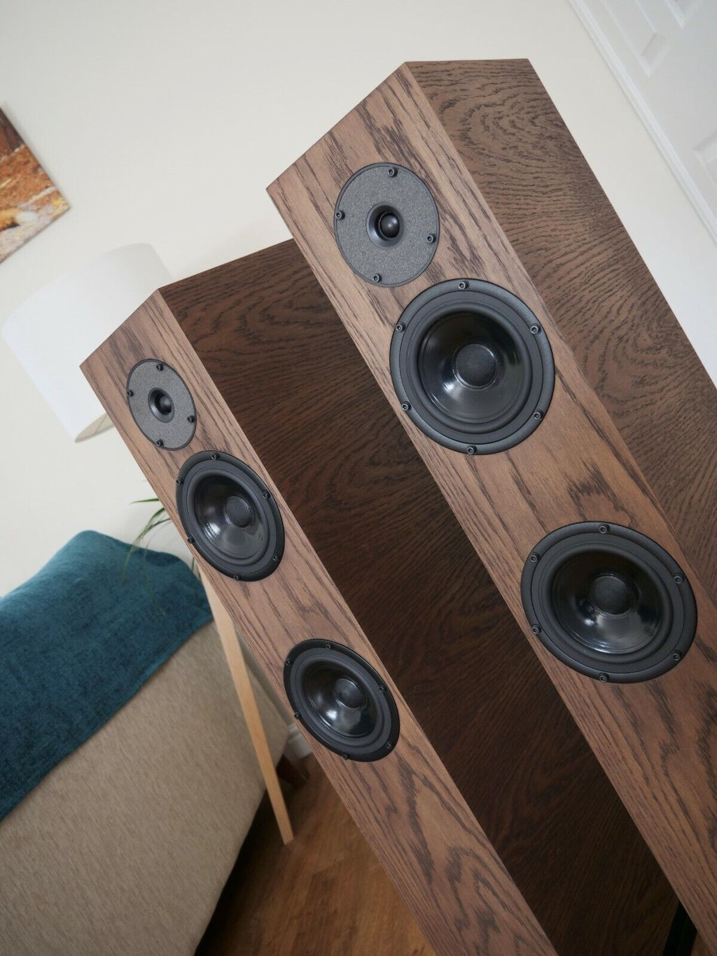 Chocolate-brown floorstanding speaker pair showing black circular driver faces and tweeters