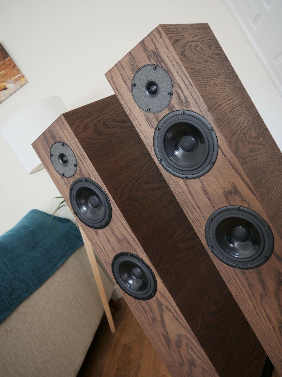 Chocolate-brown floorstanding speaker pair showing black circular driver faces and tweeters
