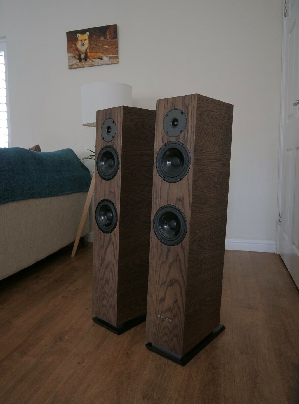 Chocolate-brown floorstanding speaker pair with multiple black woofer and tweeter grilles