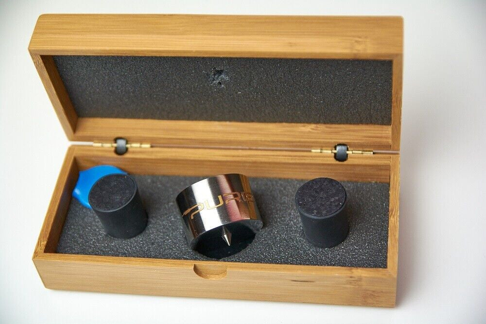Open wooden case with metal roller and three round black felt pads