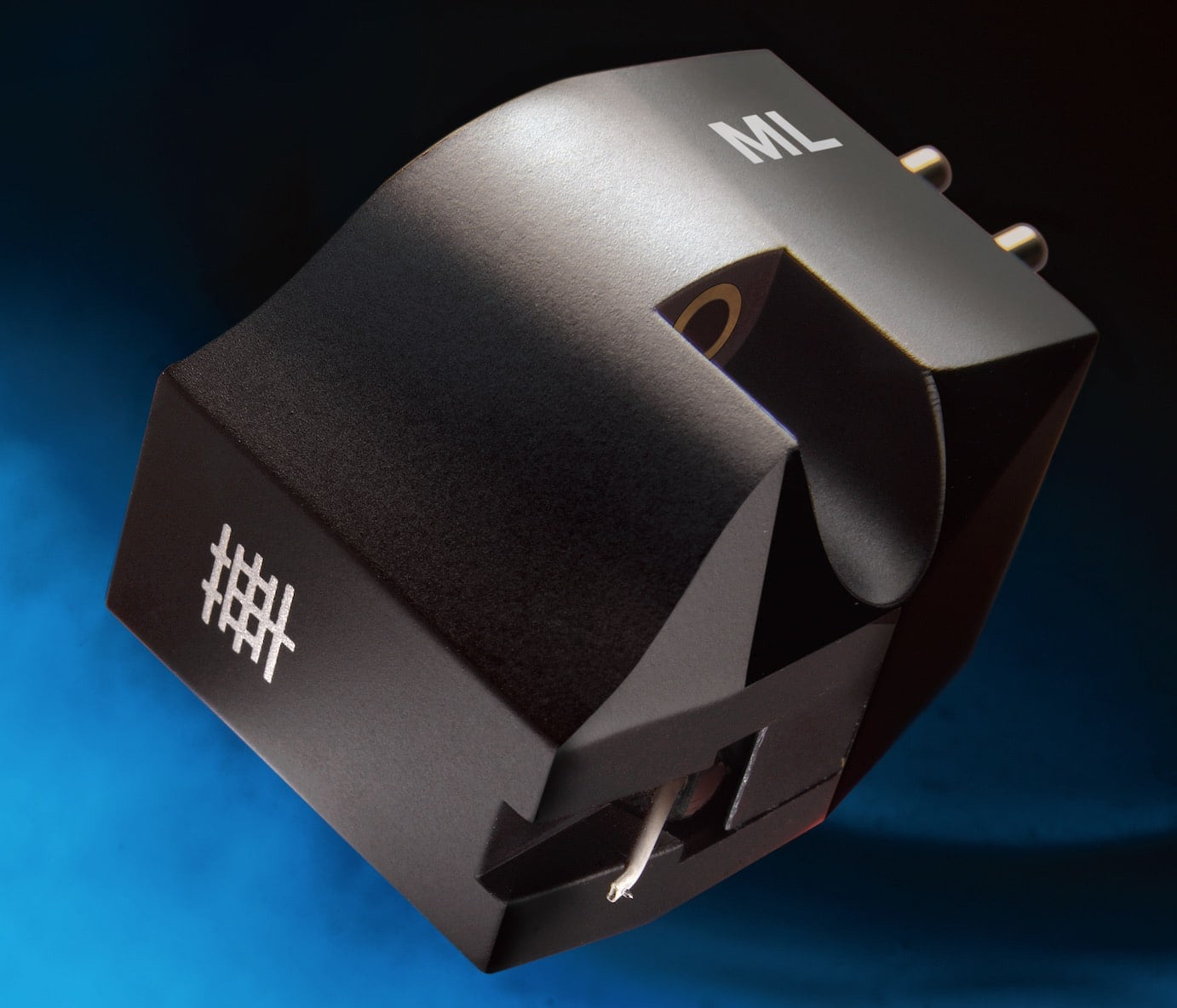 A close-up studio shot of a black audio phono cartridge, showing the ML marking and a stylus tip, set against a dark blue gradient background.