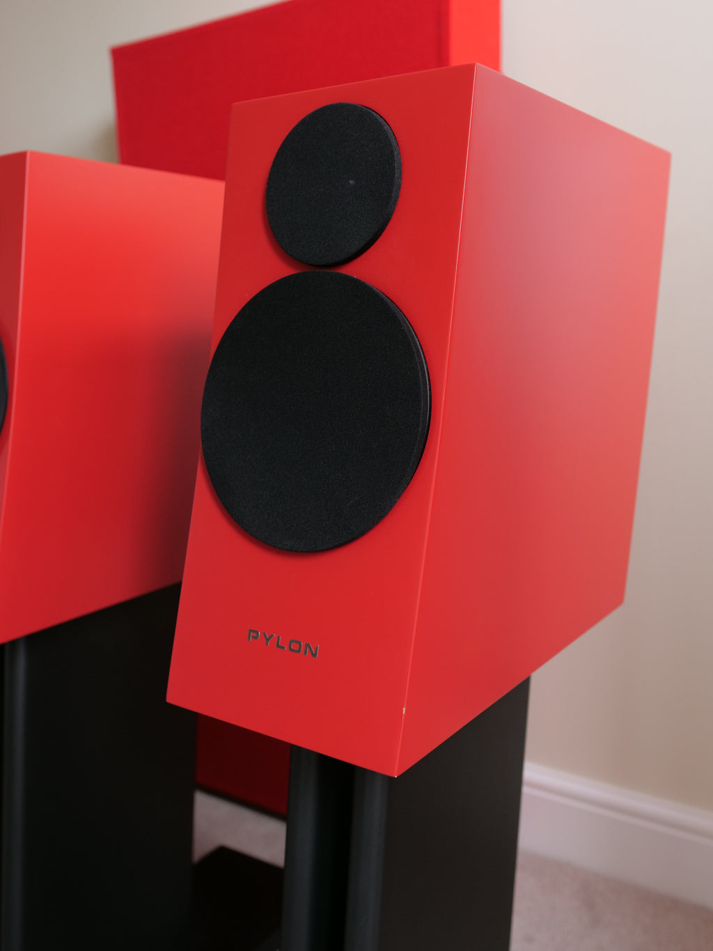 Red floor speaker with two black drivers and PYLON logo on black stand