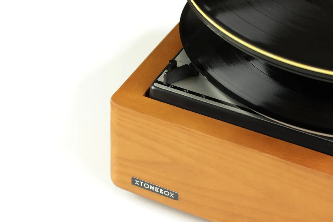 Xtonebox 121ST turntable side view showing tonearm and black vinyl platter