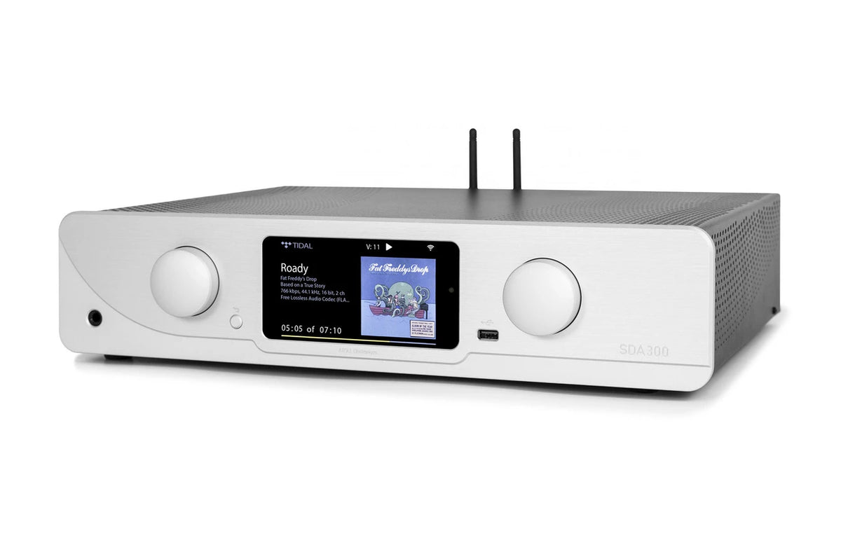 A silver  Atoll streaming amplifier with a central display screen, two large white front knobs, and two black antennas on top, shown against a plain white background.