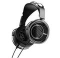 A pair of over-ear wired headphones with a black and silver metallic finish, shown from a three-quarters angle on a solid white background.