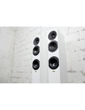 Pair of white floorstanding loudspeakers with multiple black drivers on the front
