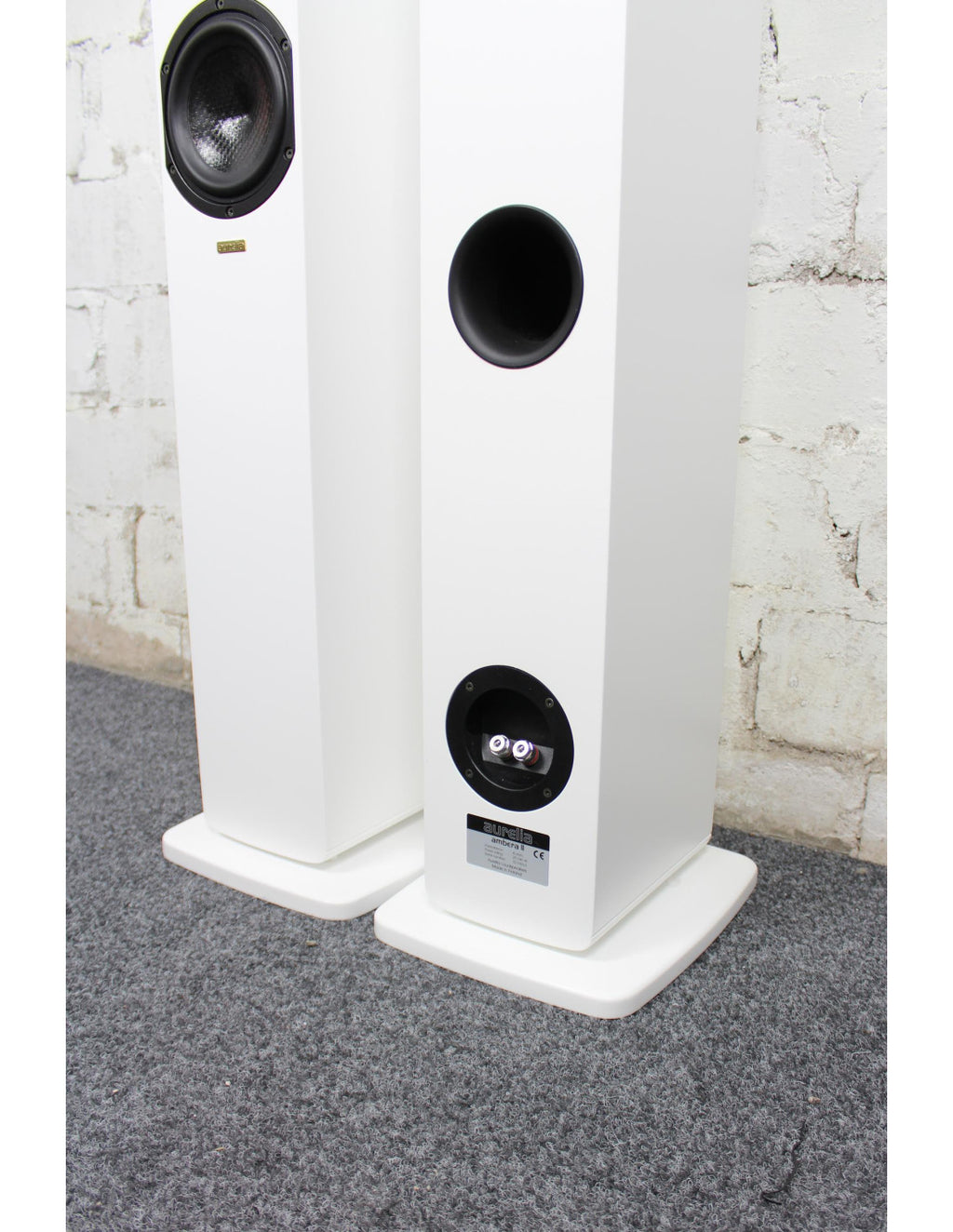 White floorstanding loudspeakers with black woofers and tweeters, front view