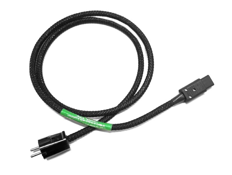 A black rodium braided audio or power cable coiled on a white background, featuring a green label and black connector ends.