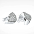Silver-tone wireless earbuds with heart-shaped glitter face and white silicone tips