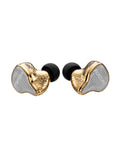 A pair of in-ear monitors with textured gold and silver outer shells and black silicone ear tips, shown on a plain white background.